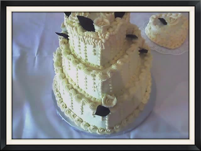 3 tier stacked vanilla pound cake with butter cream icing, iced vanilla roses with mini heart satellite cakes $450